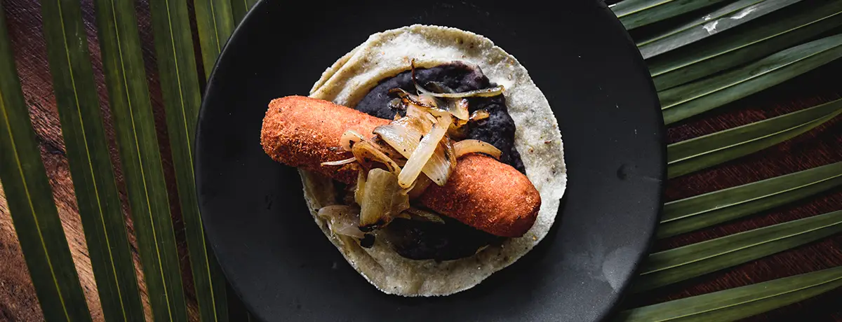 Taco of ham  and cheese roll, breaded.